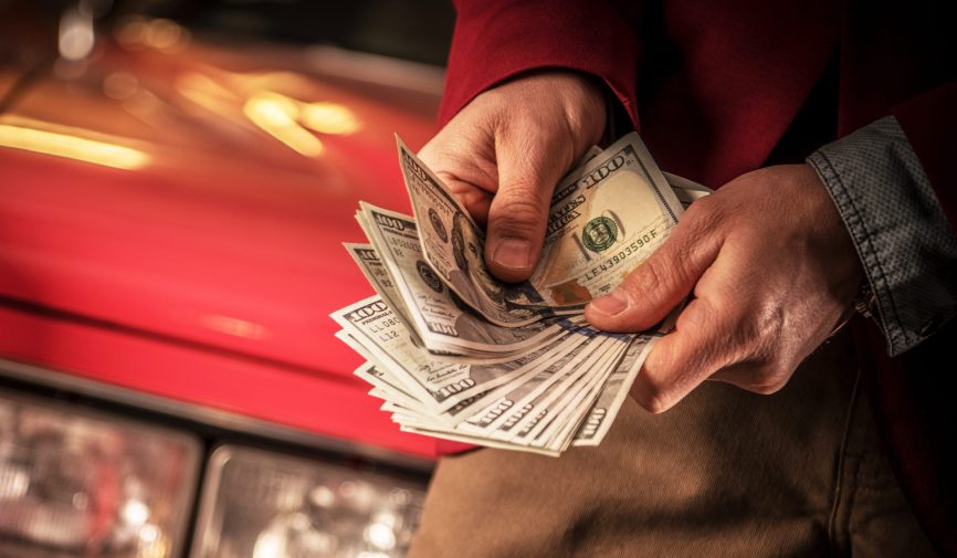 Caucasian Men Counting Cash Money in Front of His Recently Sold Car.